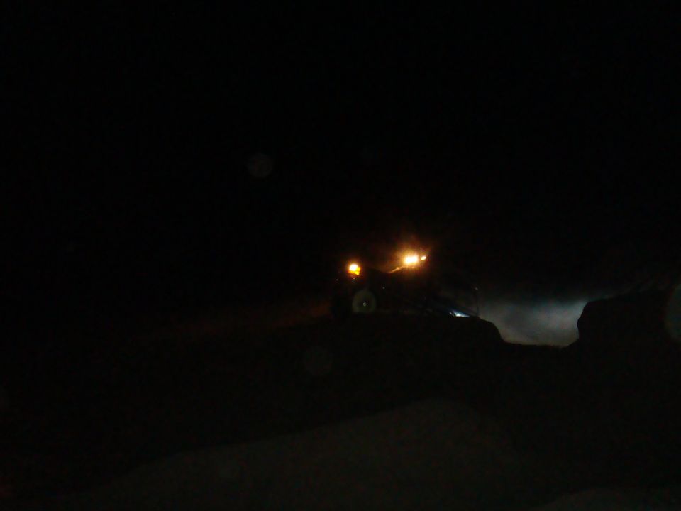 Off-road vehicle with headlights on driving at night
