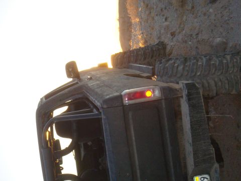 1992 Ford Bronco - This SUV appears to have rolled and is now stuck against a large rock formation, with its rear light still on.