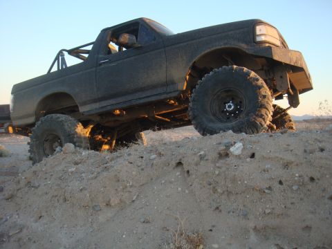 1992 Ford Bronco - Modified 1992 Ford Bronco with off-road tires and roll cage navigates rough terrain.