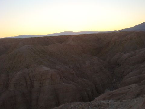1992 Ford Bronco - A vast desert landscape unfolds under a soft sunset sky, with hills and distant mountains dominating the view.