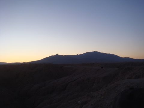 1992 Ford Bronco - The sun sets over a vast desert landscape, casting long shadows across the terrain.
