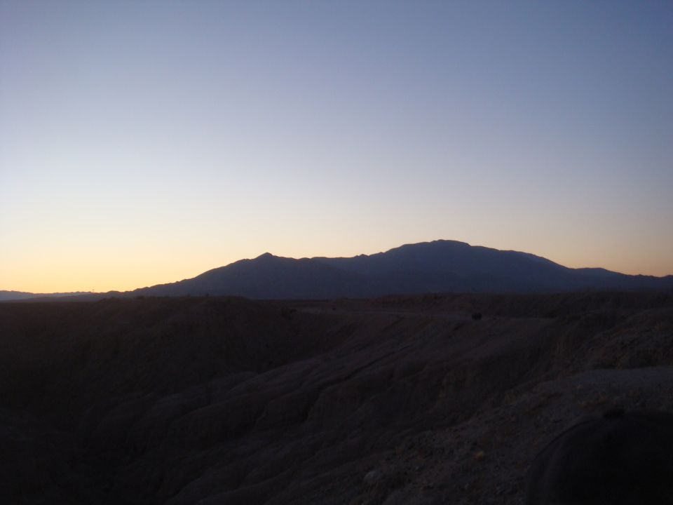 Desert mountains and terrain at sunset with a clear sky