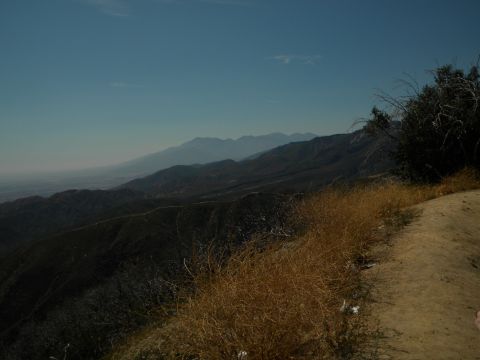 1992 Ford Bronco - A scenic view of mountains and valleys under a clear blue sky, with dry grass in the foreground.
