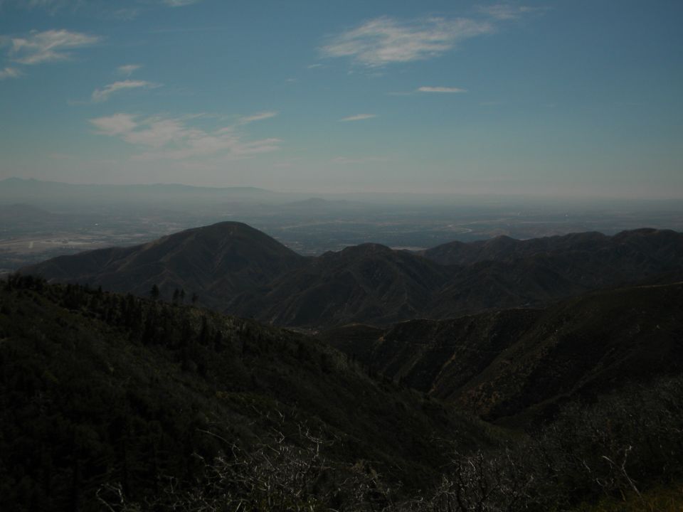 Mountain range under a hazy sky with a distant valley