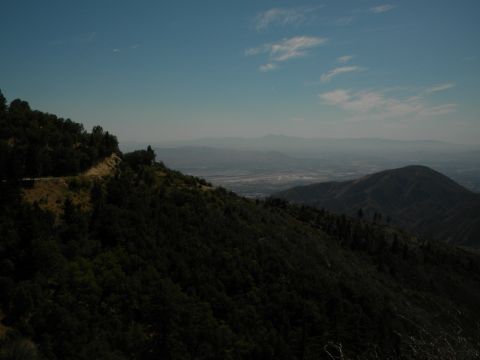 1992 Ford Bronco - A scenic overlook on a mountain road provides a vast view of a valley and distant mountain ranges.