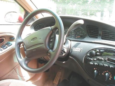 1997 Ford Taurus - The interior of a 1997 Ford Taurus shows the steering wheel, dashboard, and center console.