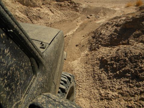 1992 Ford Bronco - Off-road vehicle driving through a dry, rocky terrain.