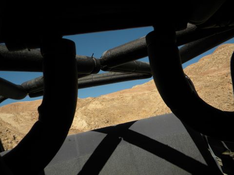 1992 Ford Bronco - View from inside a vehicle looking out at a desert landscape through a roll cage.
