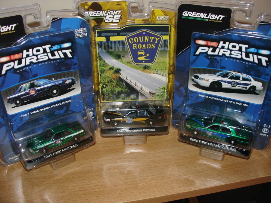Three carded GreenLight 1:64 police die-cast cars including 2008 Ford Crown Victorias