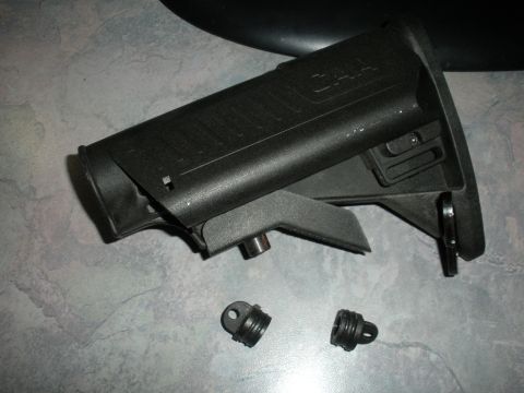 1996 Ford Bronco - A black gun stock with "CAA" branding is shown with two small threaded components on a textured surface.