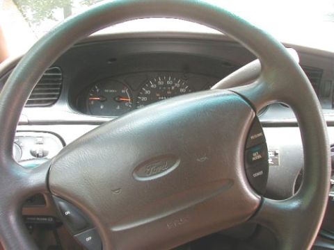 1997 Ford Taurus - The interior of a 1997 Ford Taurus is visible, focusing on the steering wheel and dashboard instrumentation.