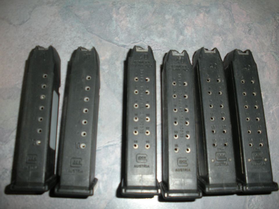 Six black gun magazines with visible caliber markings