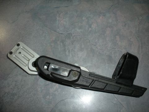 1996 Ford Bronco - A vehicle part, possibly a bracket or mount, is shown against a textured surface.