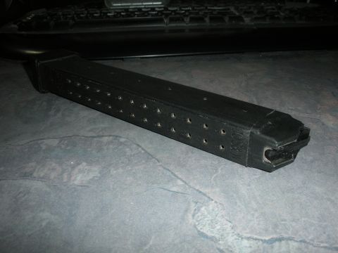 1996 Ford Bronco - A close-up view of a black gun magazine rests on a textured surface.