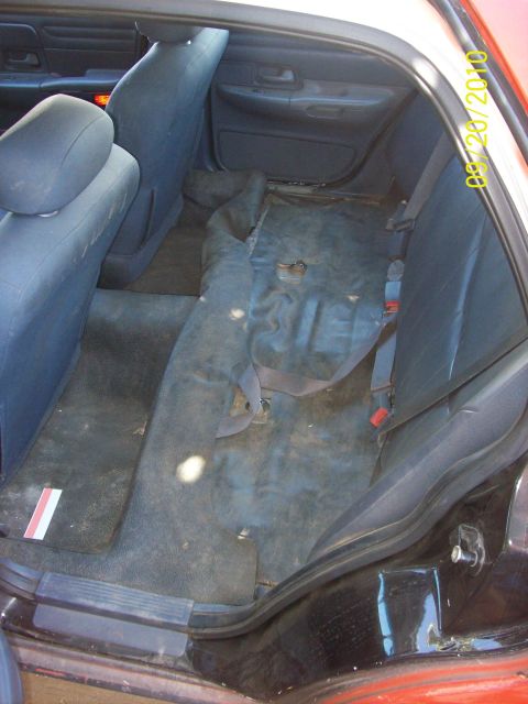 2002 Ford Crown Victoria - The interior of a 2002 Ford Crown Victoria is visible, with blue cloth seats and a worn floor.