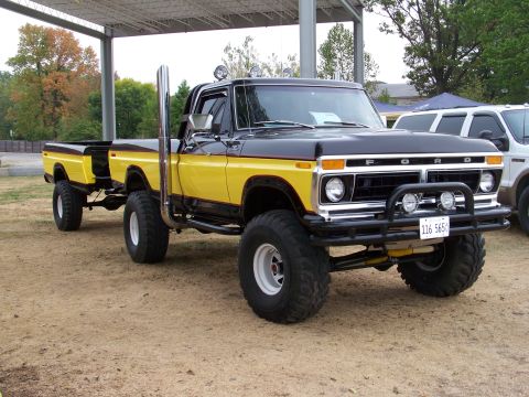 1989 Ford Bronco - This modified Ford pickup truck, likely from the late 1970s, is equipped with oversized tires and a prominent exhaust stack.