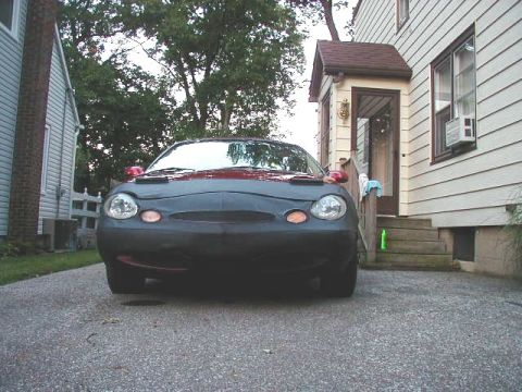 1997 Ford Taurus - A 1997 Ford Taurus is parked in a driveway, partially covered with a dark car bra.