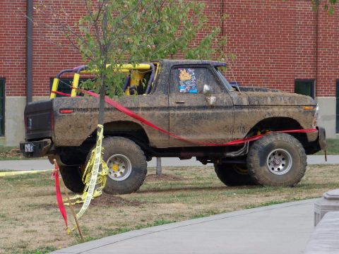 1989 Ford Bronco - This heavily modified 1978 Ford Bronco is covered in mud, a prominent roll cage and off-road tires.