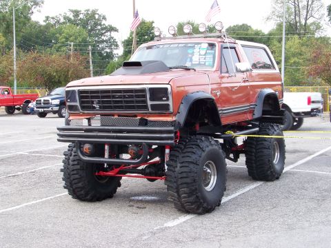 1989 Ford Bronco - This heavily modified SUV features a prominent hood scoop and oversized tires, suggesting a custom build rather than a stock 1989 model.