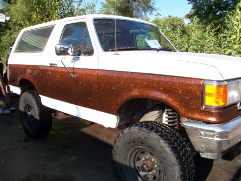 1989 Ford Bronco - This 1989 Ford Bronco features a lifted suspension and a unique brown metallic paint job on its lower body.
