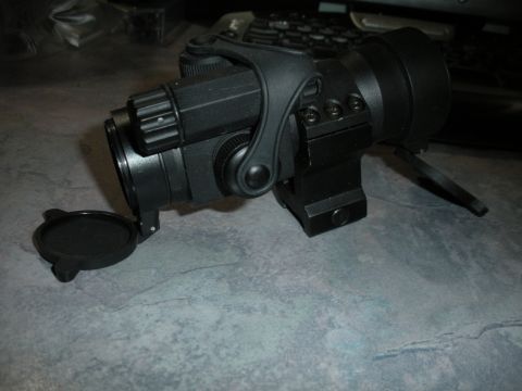 1996 Ford Bronco - Close-up of a black optical scope mount with a flip-up lens cap.
