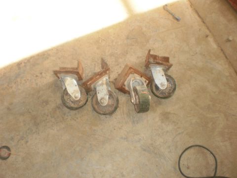 1995 Ford Bronco - Four old casters are shown lying on a concrete surface.
