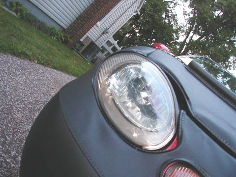 1997 Ford Taurus - A car bra covers the front of the vehicle, showing only the headlight and part of the grille area.