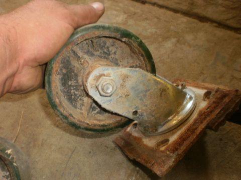 1995 Ford Bronco - Close-up of a rusty caster wheel and its mounting plate.