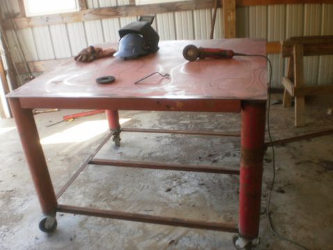 1995 Ford Bronco - Welding table setup with helmet, gloves, and angle grinder in a workshop.