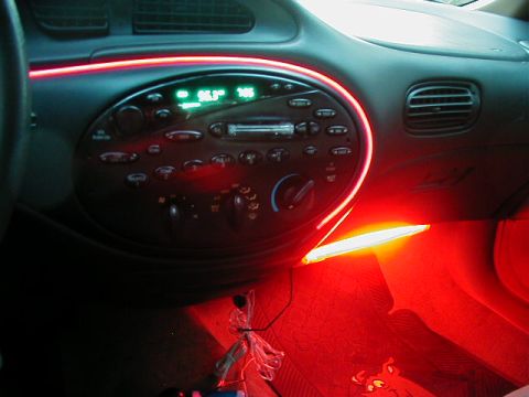 1997 Ford Taurus - The interior of a 1997 Ford Taurus features red ambient lighting accenting the dashboard and center console.