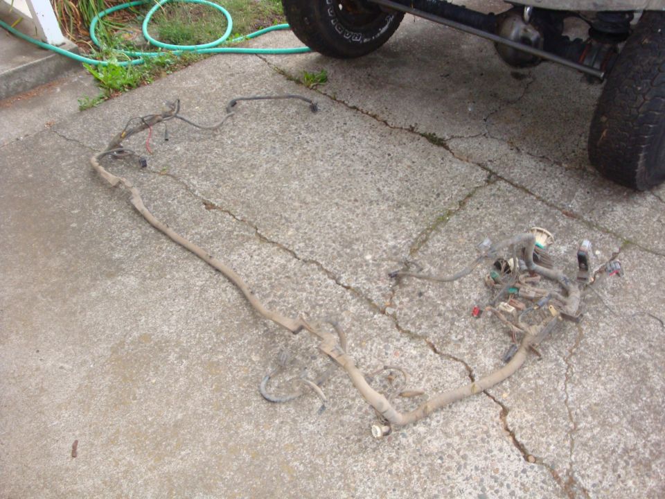 Truck wiring harness laid out on a concrete driveway with connectors bundled