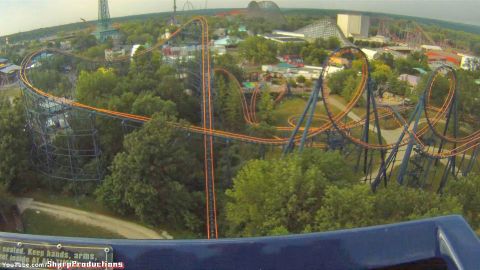 1993 Ford Taurus - A roller coaster with orange tracks and blue supports snakes through a wooded amusement park.