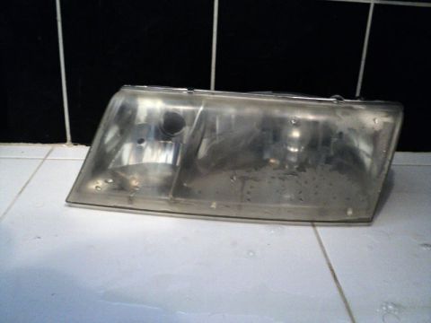 2001 Mercury Grand Marquis - This headlight shows significant yellowing and hazing on its lens, indicating a need for restoration.