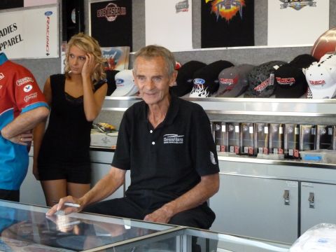 1992 Ford Mustang - People stand behind a counter in a store filled with hats and apparel.