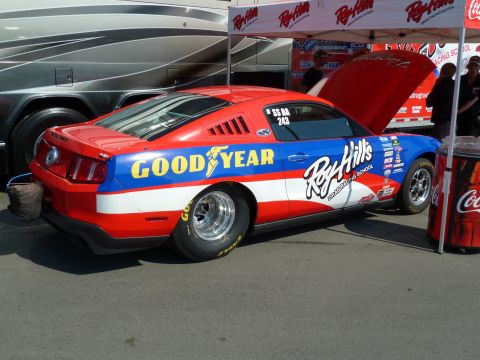 1992 Ford Mustang - This drag car, prominent Goodyear and Roy Hill's Drag Racing School branding, is seen from the side with its hood open.
