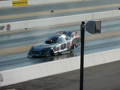 1992 Ford Mustang - A funny car drag racer speeds down the track during a competition.