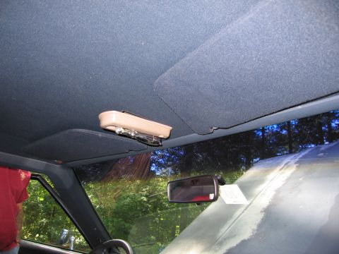 1991 Ford LTD Crown Victoria - Interior view of a car's ceiling, showing a sunglasses holder and a rearview mirror with a paper attached.