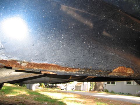 1991 Ford LTD Crown Victoria - Close-up of severe rust on the undercarriage of a vehicle.