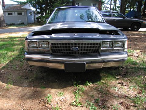 1991 Ford LTD Crown Victoria - The front grille and headlight design are characteristic of the 1991 Ford Crown Victoria, seen here with its hood ajar.