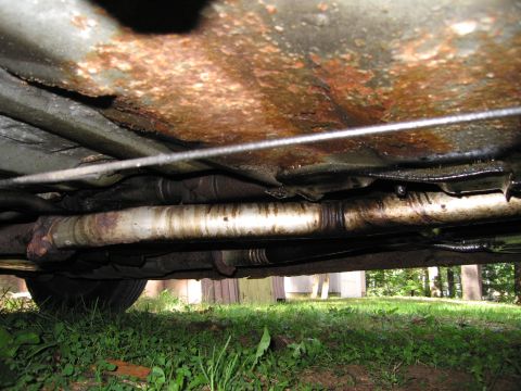 1991 Ford LTD Crown Victoria - The underside of the vehicle shows significant rust on the frame and exhaust components.
