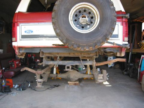 1985 Ford Bronco - Rear axle and suspension work on a 1985 Ford Bronco, spare tire visible.