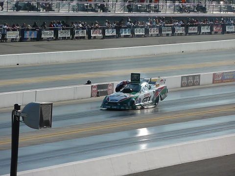 1992 Ford Mustang - Funny car drag racer speeds down the track during a competition.