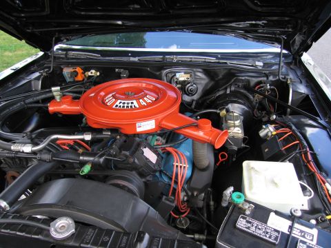 1991 Ford LTD Crown Victoria - detailed V8 engine compartment with a glossy orange '440 Four Barrel' air-cleaner lid, red wiring and chrome trim under an open hood.