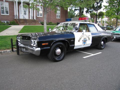 1991 Ford LTD Crown Victoria - black-and-white Dodge Highway Patrol sedan with chrome push bar and HIGHWAY PATROL lettering on the rear door.