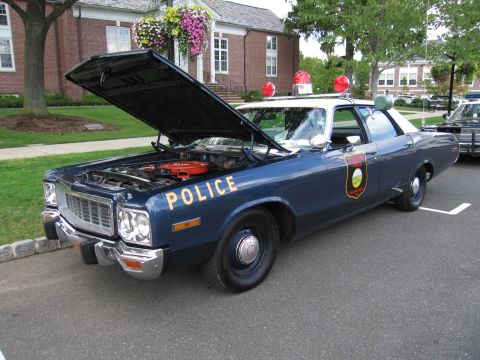 1991 Ford LTD Crown Victoria - blue police sedan marked POLICE in gold with its hood up, exposing the engine and air cleaner.