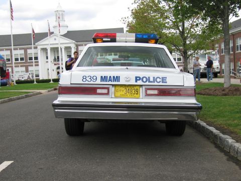 1991 Ford LTD Crown Victoria - Direct rear view of a white Miami Police sedan numbered 839 with a Florida plate and roof light bar.