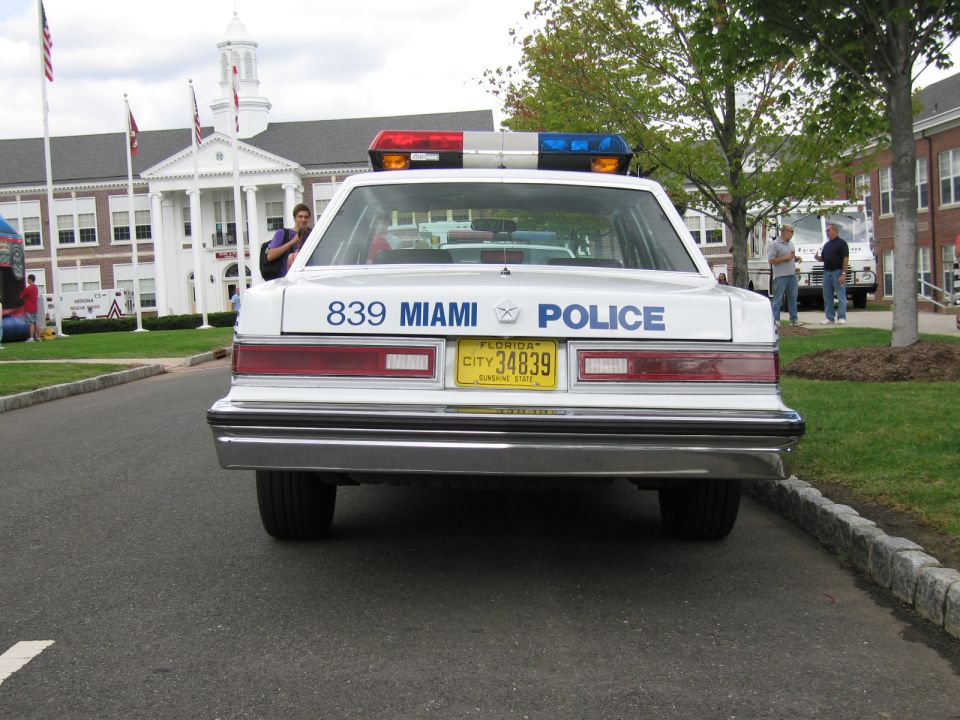 White Miami Police sedan numbered 839, direct rear view with Florida plate