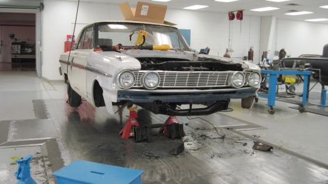 1992 Ford Mustang - A white 1964 Ford Falcon is shown on jack stands in a workshop, undergoing repairs.