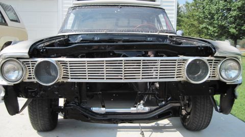 1992 Ford Mustang - The front grille and headlights of a classic Ford Fairlane are visible, with the hood open and engine bay exposed.