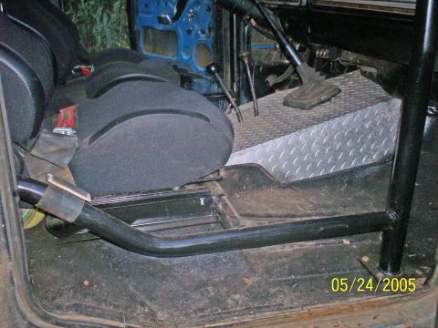 1978 Ford Bronco - The interior of a vehicle is shown, aftermarket seats and a roll cage structure.